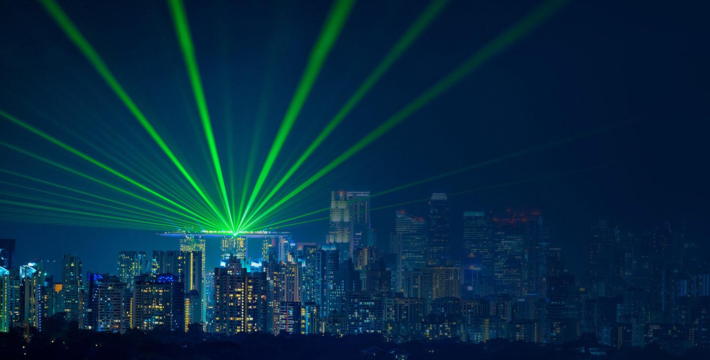 城市天际线的景色，明亮的绿色灯光从一座建筑中照射出来